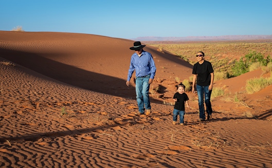 Navajo familyof 3  in the sand dunes in Monument Valley - Utah