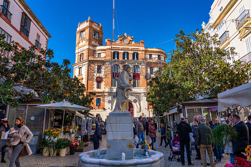 Cadiz, Spain - Nov 16, 2022: The Plaza de Topete aka Plaza de las Flores with the main post office in the background. With its cafes and boutiques, it is one of the citys liveliest squares.