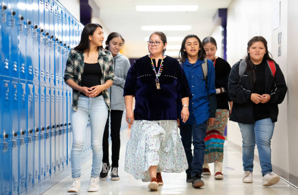 istock Proud Teacher walking with a group of students thru a corridor 1443604960