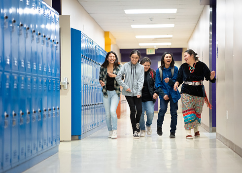 Indigenous navajo group of happy students walking on the corridor