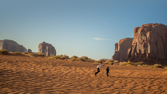 Brother nad sister playing on the sand dunes of Monument Valley Utah