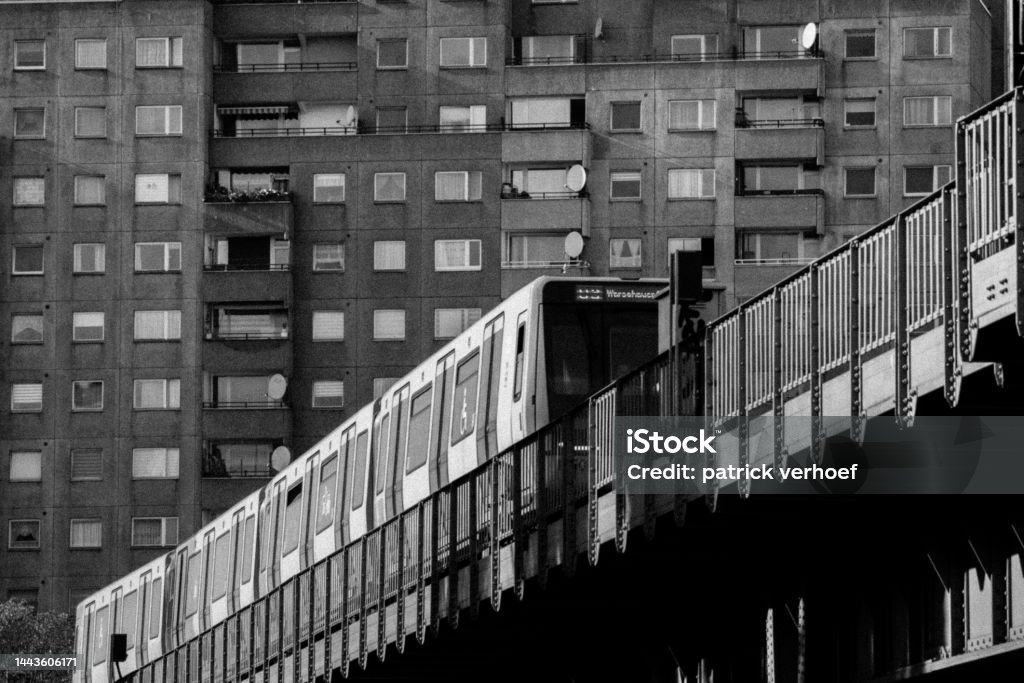 black and white picture of a subway train in berlin in front of a brutalist building black and white picture of a subway train in berlin Architecture Stock Photo