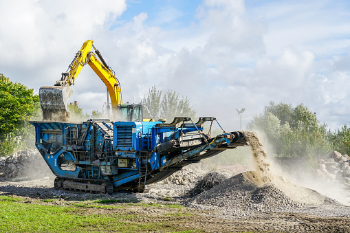 Mobile concrete and reinforced concrete construction debris crushing machine in action, construction debris recycling into finer fractions