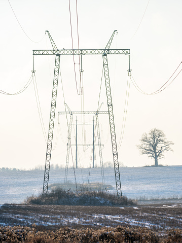 Electric high voltage tower with electric line in winter