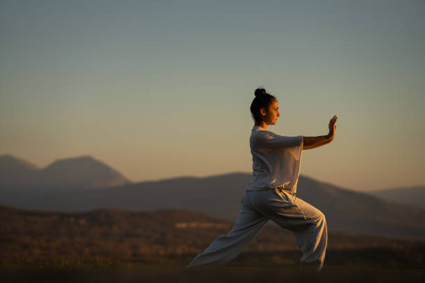 istock Woman doing tai chi in sunset 1443609011