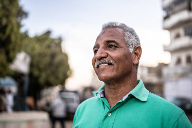 Mature man looking away contemplating outdoors Mature man looking away contemplating outdoors north african ethnicity stock pictures, royalty-free photos & images