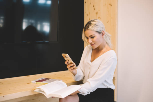 istock Cheerful successful female manager using cellphone in business center 1443611592