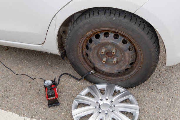 istock Man inflates tire with air 1443612298