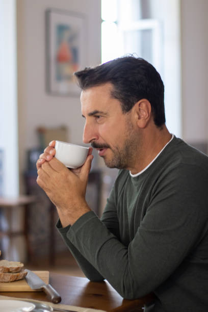 istock Bearded Caucasian man drinking coffee in morning at home 1443614970