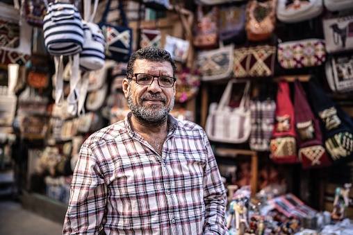 Portrait of a mature man in front of his store on a bazaar market