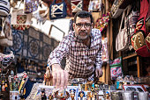 Portrait of a business owner arranging souvenir in his store