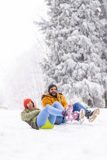 istock Couple sliding down the hill while on winter vacation 1443624770