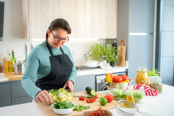 istock Mature woman preparing fresh salad bowl 1443625664