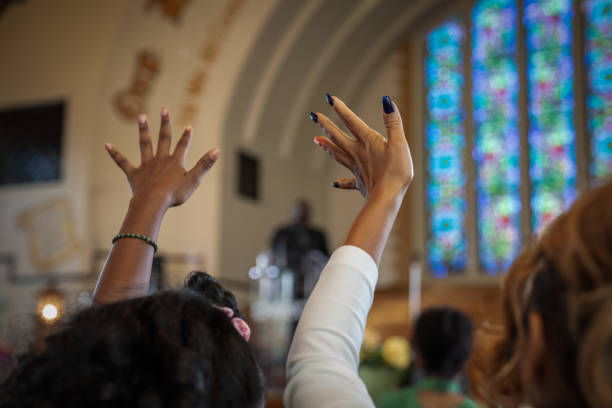 Black Congregation attend Black Baptist Church service Group of African Americans attending church and listening to a pastor speak. clergy stock pictures, royalty-free photos & images