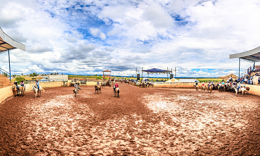 Rodeo con tierra y lodo y jinetes montando caballos bajo un cielo con nubes en monte Escobedo Zacatecas