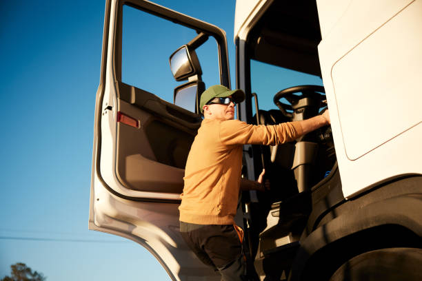 Truck driver getting into truck ready to depart stock photo