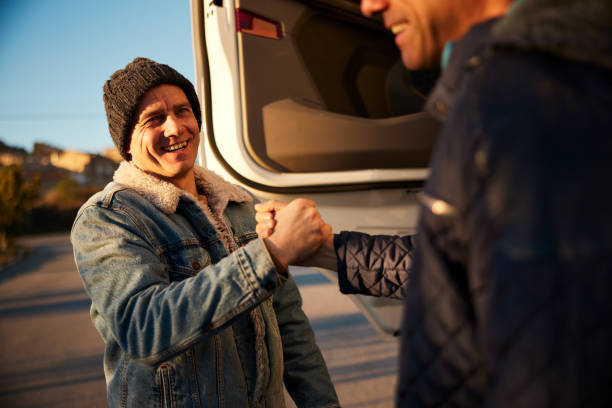 Two trucker friends, happy to see each other again, shaking hands. stock photo