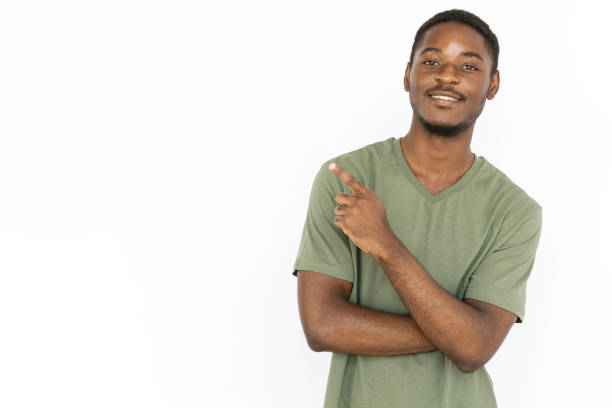 istock Cheerful young man pointing with finger at copyspace advertising 1443627537