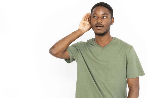 istock Listening young Black man with hand over ear 1443627578