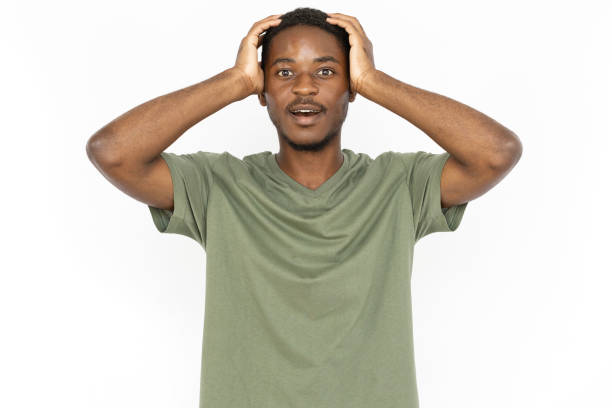 istock Surprised young man holding hands on his head from shock 1443627641