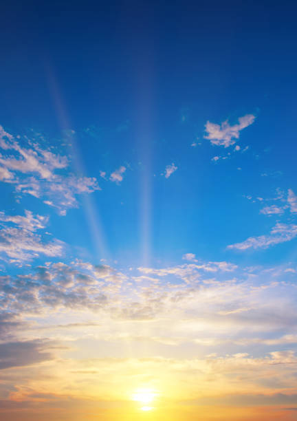 Sunset with strong color clouds light rays . Vertical photo.