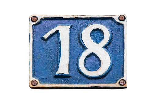 Old retro weathered cast iron plate with number 18 closeup isolated on white background