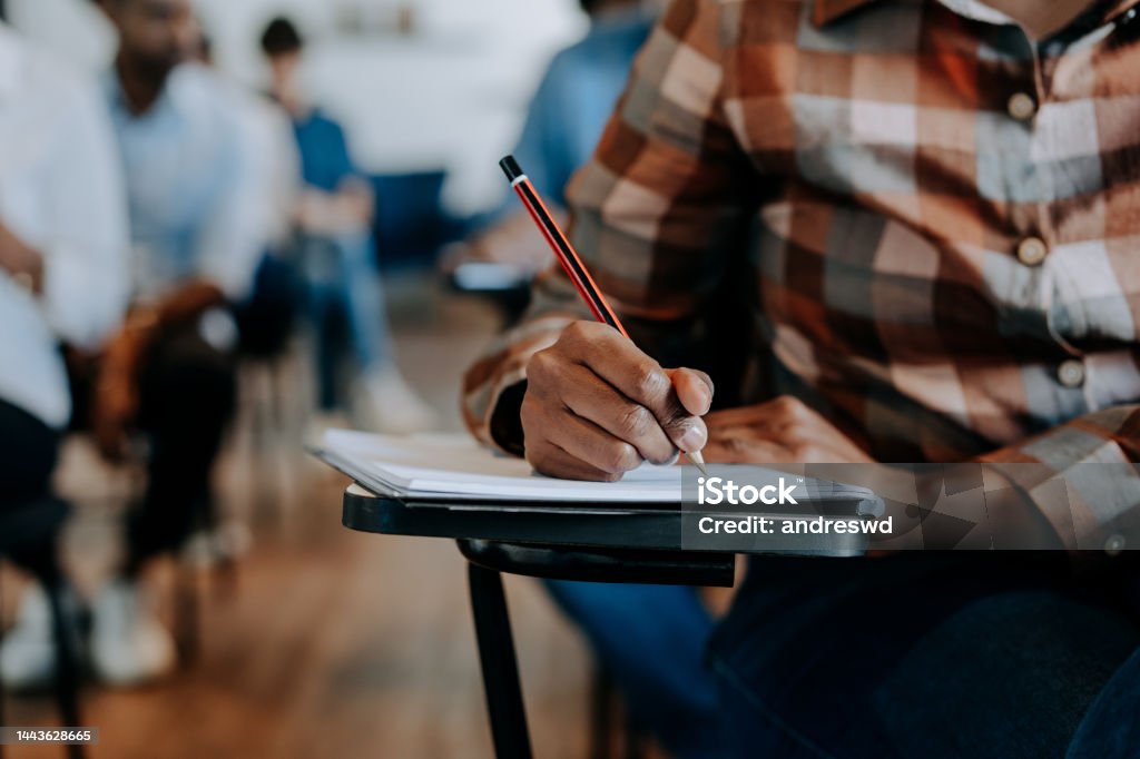 Adult writing in the classroom Educational Exam Stock Photo