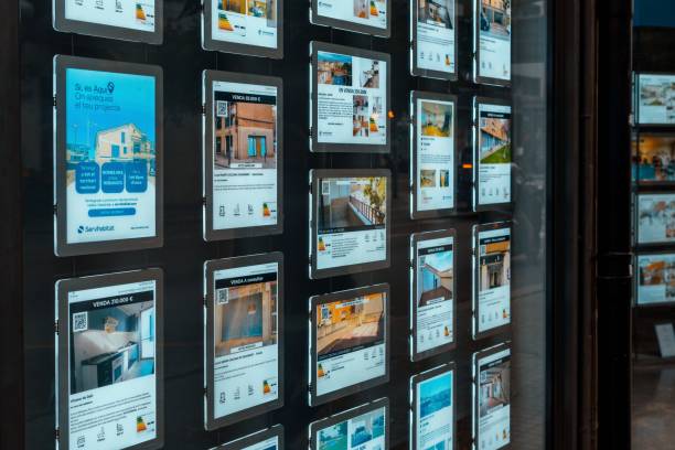 escaparate de una agencia inmobiliaria con anuncios de pisos en venta o alquiler. concepto de aumento de los tipos de interés hipotecarios - pisos alquiler fotografías e imágenes de stock