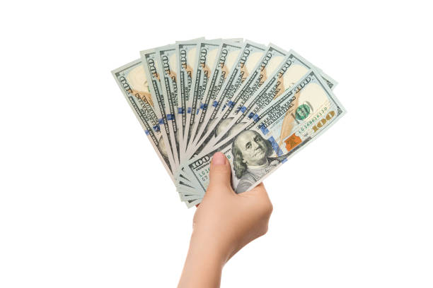 istock Hand holding US money, 100 dollar bills isolated on a white background. 1443629909