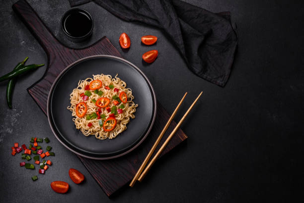 Delicious fresh noodles with sweet pepper, tomato, spices and herbs