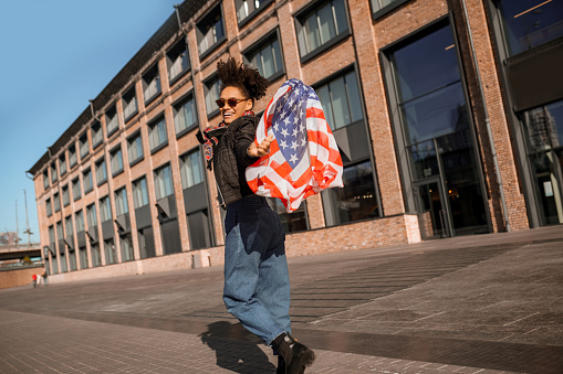 Independence day. A dark-skinned girl with american flag in hands