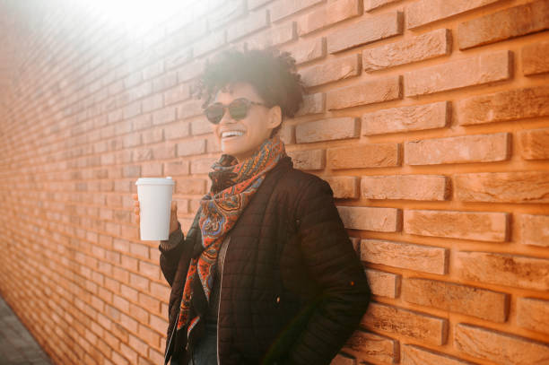 istock A cute girl in sunglasses having coffee outside 1443635341