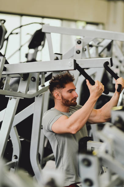 istock side view of a  man in gym sitting on bench, working out with weights 1443635451