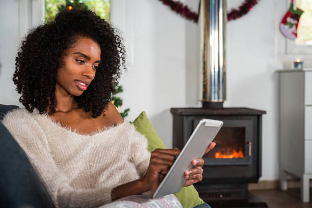 istock Black woman browsing tablet on couch 1443640445