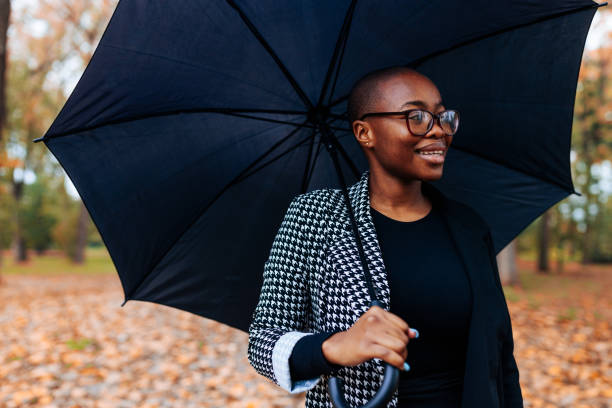 istock African American woman outdoors with umbrella. 1443642633