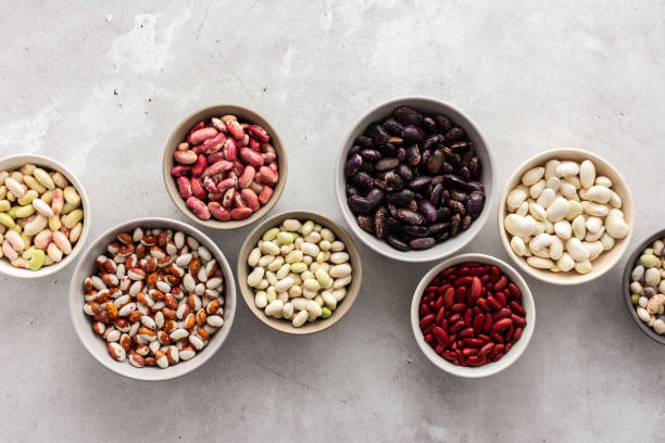 Different types of beans in bowls Different types of beans in bowls, economically important legume, top view, copy space bean stock pictures, royalty-free photos & images