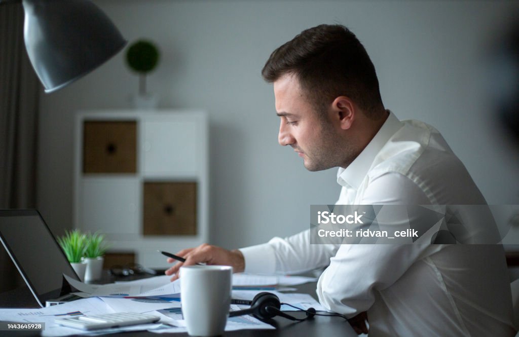 Focused businessman sit at workplace desk working on laptop One Person Stock Photo