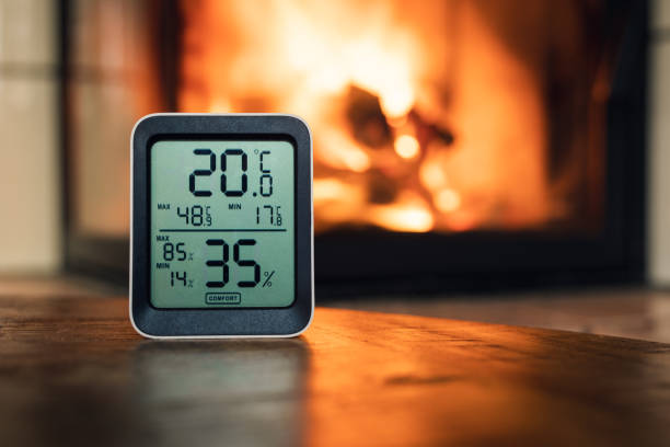 Thermometer in front of fireplace which shows temperature and humidity. Thermometer in front of fireplace which shows temperature and humidity. humidity stock pictures, royalty-free photos & images