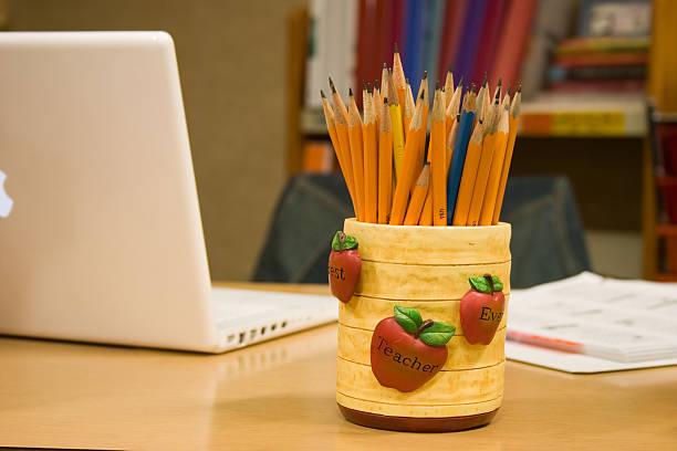 Teacher's Desk with Laptop and Pencils Picture of a teacher's desk with a laptop, jar of pencils, and grade book . guest book photos stock pictures, royalty-free photos & images