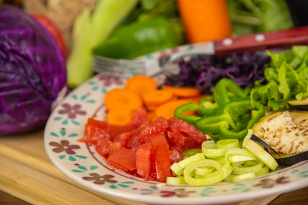 Porcelain plate with sliced vegetables. Ingredients for salads. Natural food. Vegetables for human use and consumption. Healthy eating. Vegetables and salads.