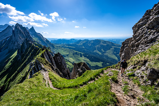 A woman is walking along the Schäfler altitude path in the Swiss alps