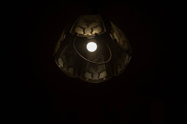 Lamp in dark. Chandelier with one lamp. Light source. Interior details.