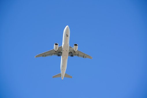 Passenger airplane flying on blue sky, low angle view