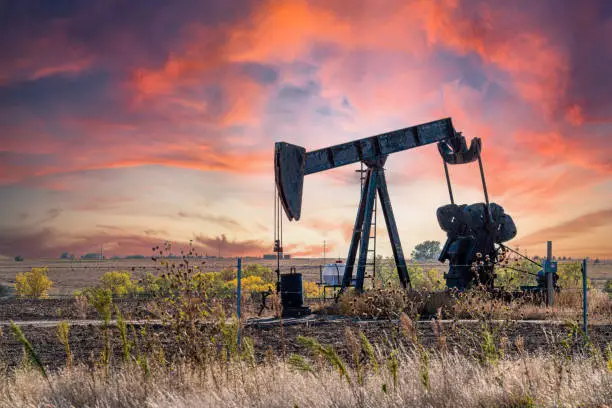 Photo of Oil Pump Jack in the Middle of Kansas with a Beautiful Sunset Background with Copy Space