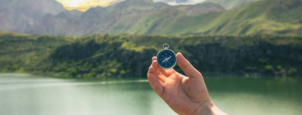 istock A man holds a compass against the backdrop of a lake 1443663183