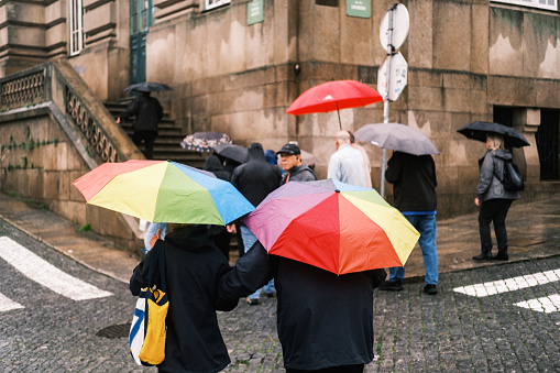 Porto, Portugal; November 20, 2022: Several people walking around the port while it was raining had to open their umbrellas