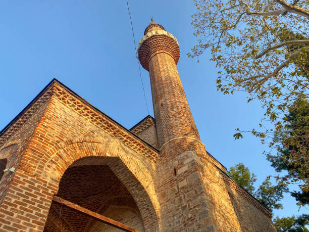 la mezquita islámica es una gran mezquita musulmana para las oraciones, un antiguo edificio de ladrillo antiguo con una torre alta en un centro turístico cálido tropical del este del país. - sunset in islamic country fotografías e imágenes de stock