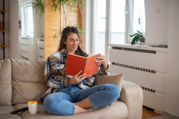 istock Happy woman reading book at home 1443667180