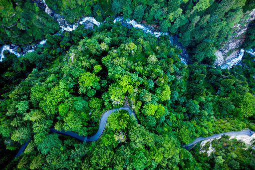 Aerial view of a winding road and a winding river side by side