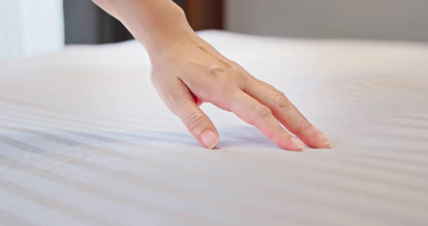 istock woman hand on bed 1443667890